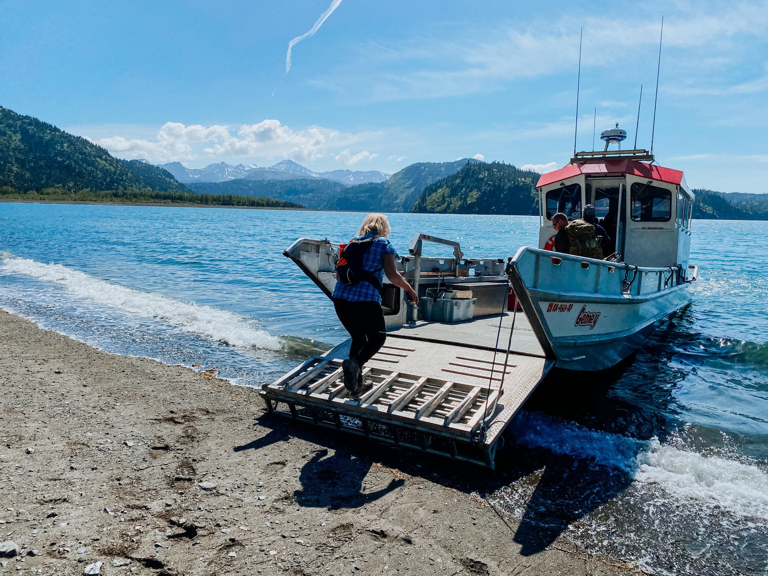 Passengers boarding landing craft on rocky Alaskan beach excursion