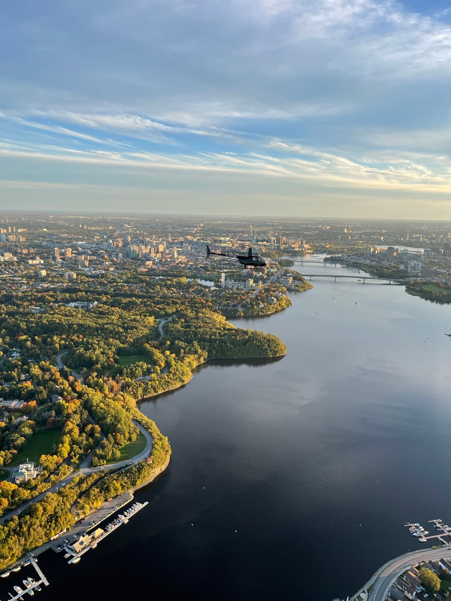 Aerial helicopter tour over river and city skyline at dawn