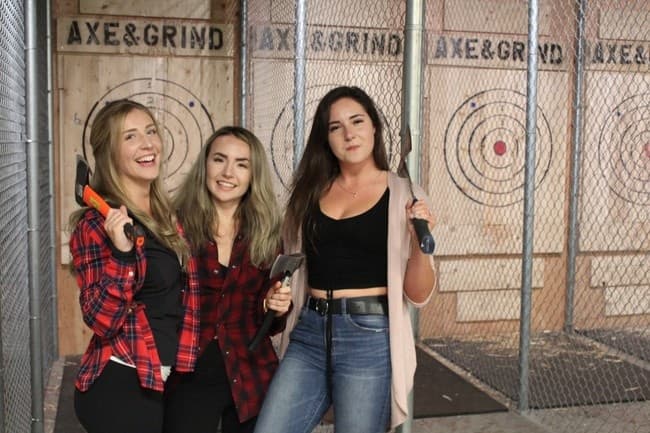 Friends celebrating after axe throws at indoor throwing lanes