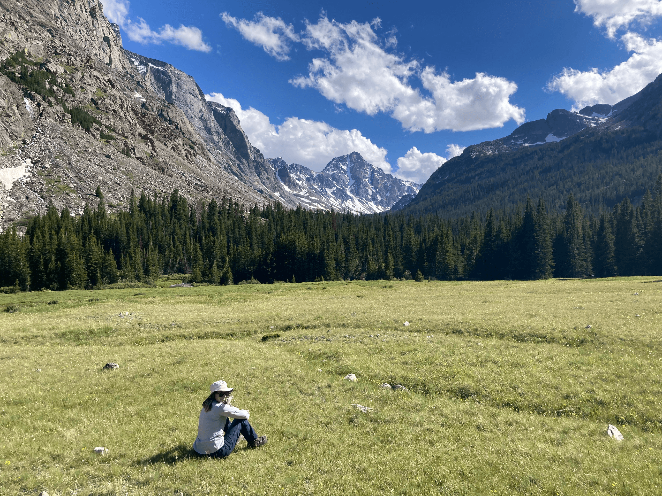 Hiker relaxing in alpine meadow with mountains in Yellowstone