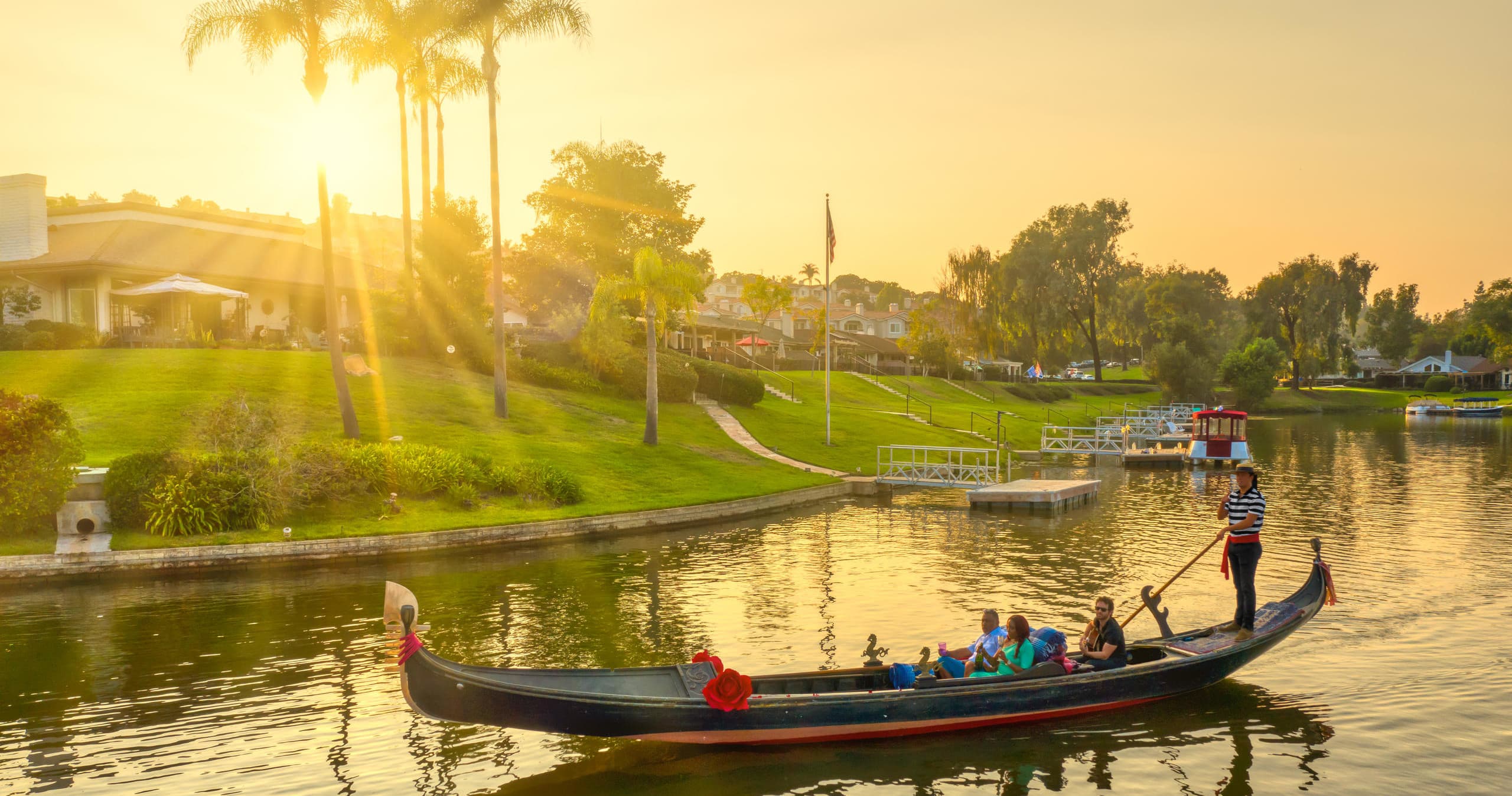 Gondola sunset tour past palm lined shoreline on tranquil lake