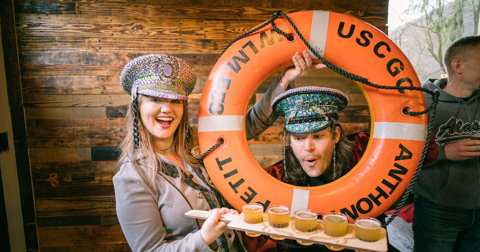 Friends holding life preserver and beer flight in Alaskan pub