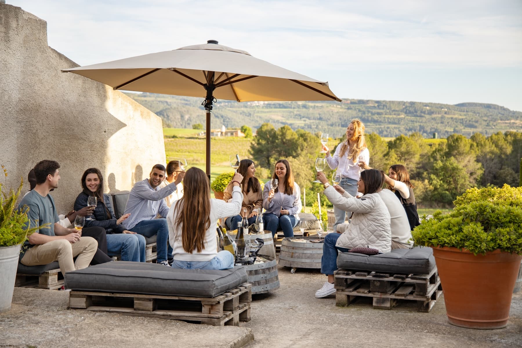 Group enjoying outdoor wine tasting on sunny vineyard terrace