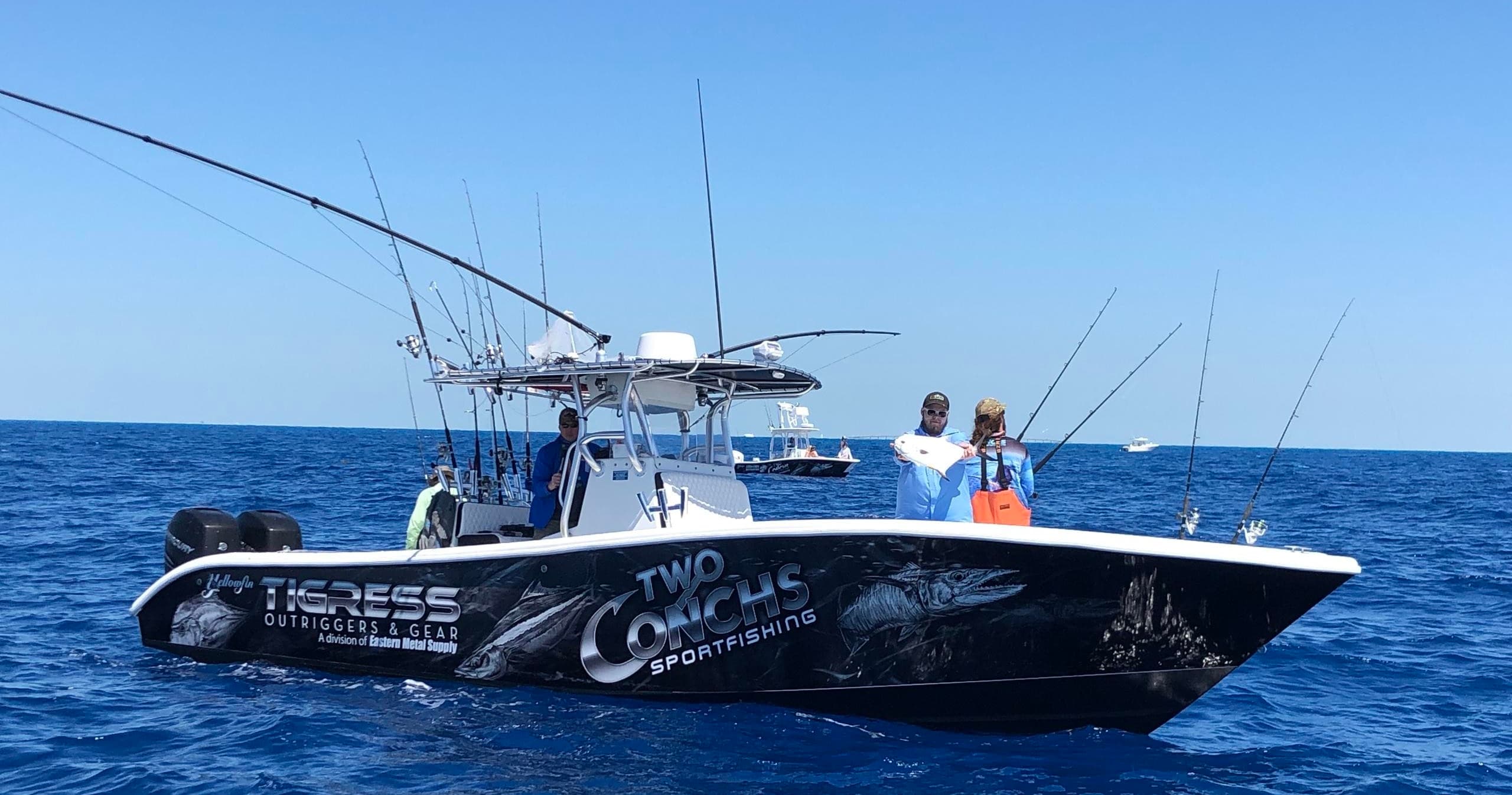 Offshore fishing boat with crew casting lines on open sea