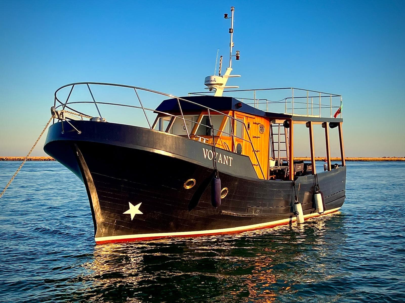 Small yacht anchored in coastal waters for leisure cruising
