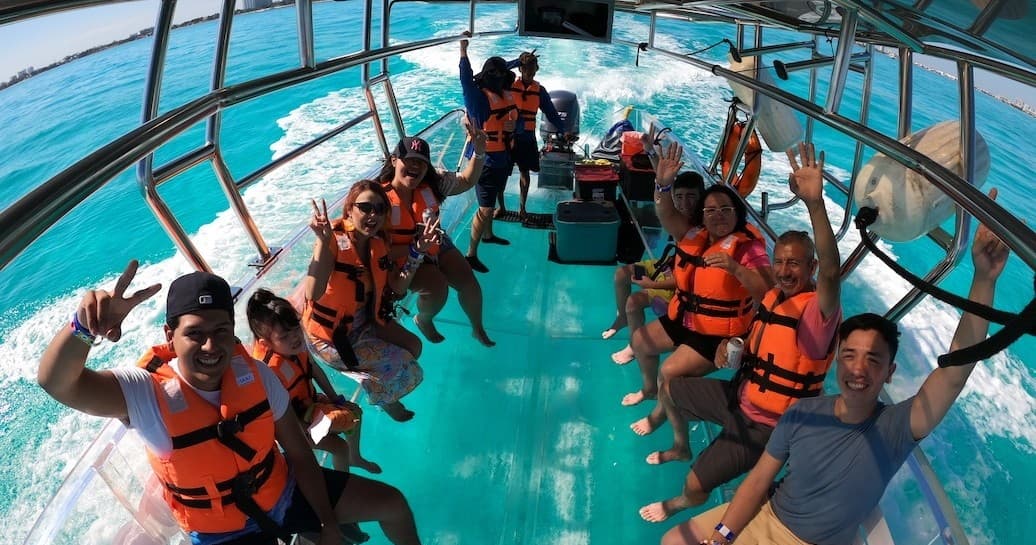Passengers on glass-bottom boat in turquoise Bahamian waters