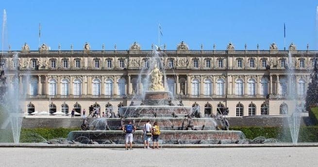 Grand palace façade with fountain, luxurious garden approach