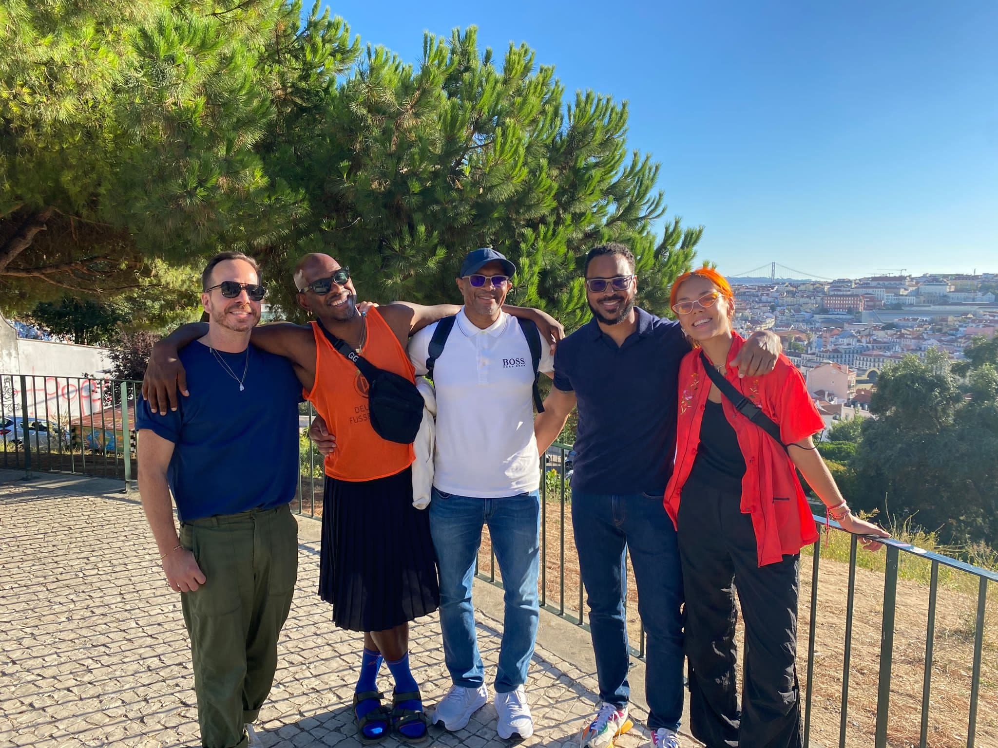 Group of friends posing on Lisbon viewpoint overlooking city