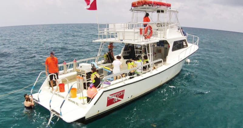 Scuba divers on dive boat in open ocean off Miami preparing to dive