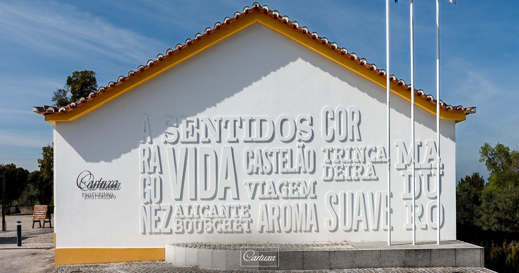 White estate building with embossed winery signage under blue sky