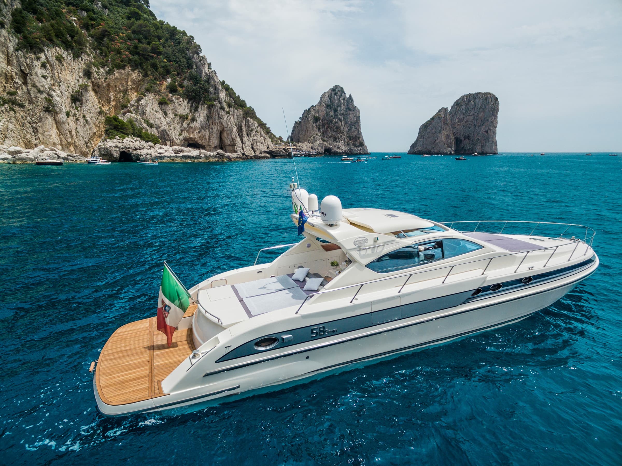 Yacht cruising past rugged cliffs on Amalfi coast near Capri