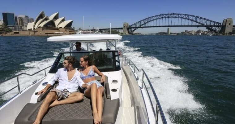 Couple relaxing on yacht bow cruising Sydney Harbour attractions