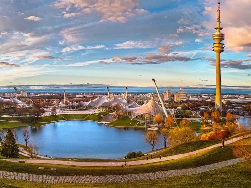 Panoramic view of Munich skyline with Olympiaturm and lake