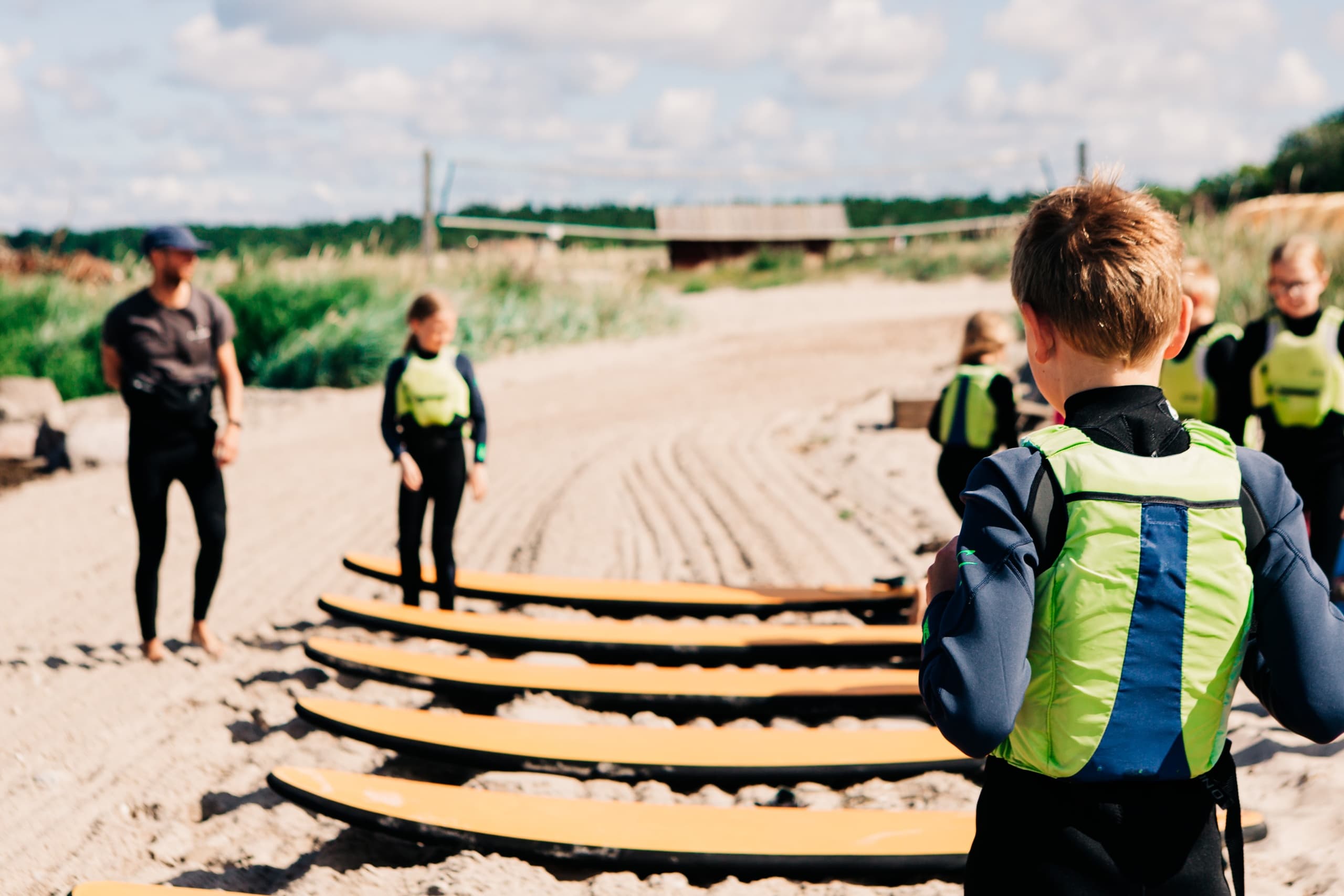 Surf lesson group with boards on sandy beach learning waves