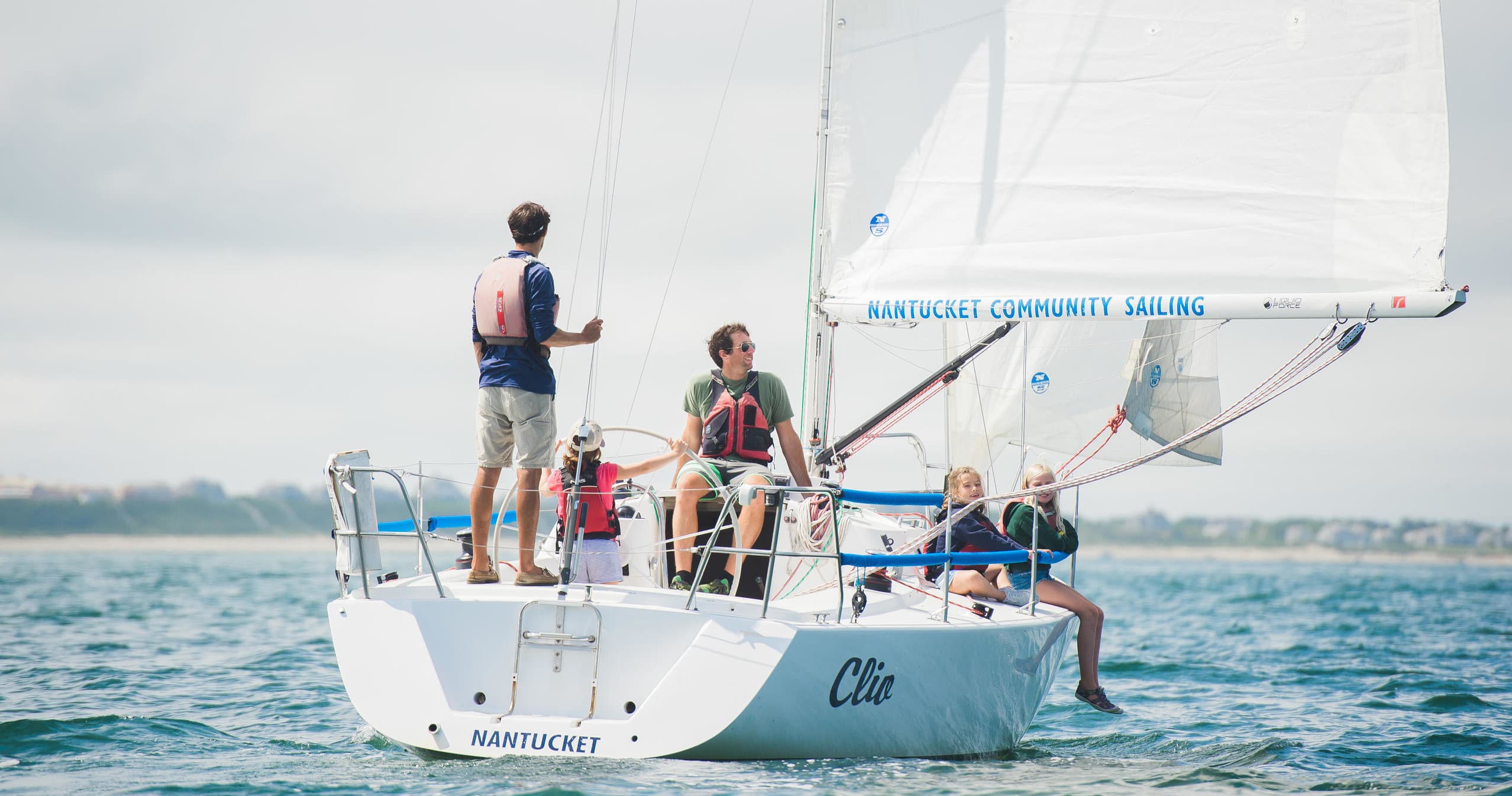 Crew sailing a keelboat off Nantucket, group aboard deck