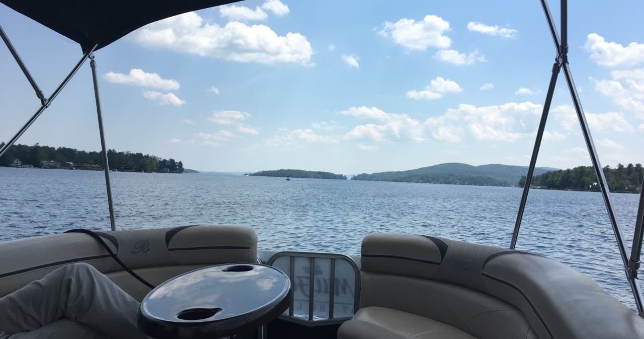 Interior pontoon seating view across serene lake and islands