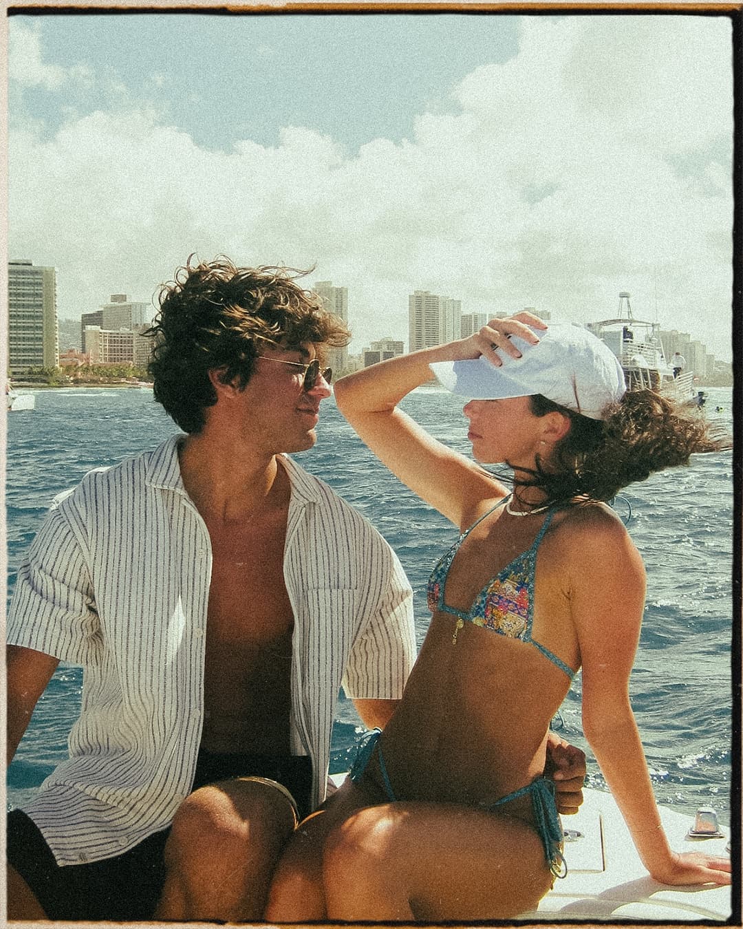 Couple on charter boat enjoying sunny Hawaiian ocean cruise