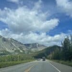 Mountain highway framed by peaks, scenic road trip drive