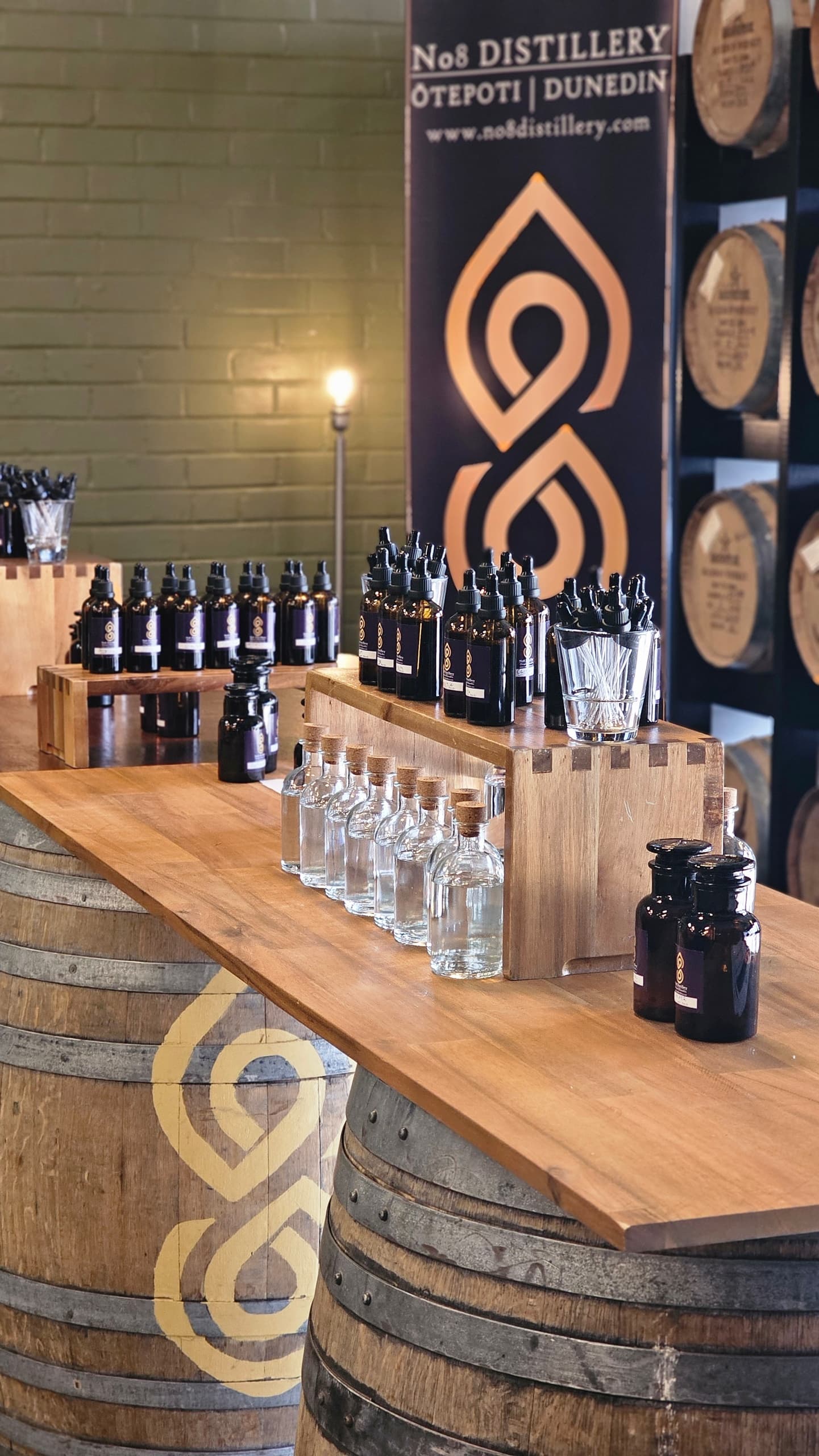 Tasting counter with bottles and wooden barrels in distillery