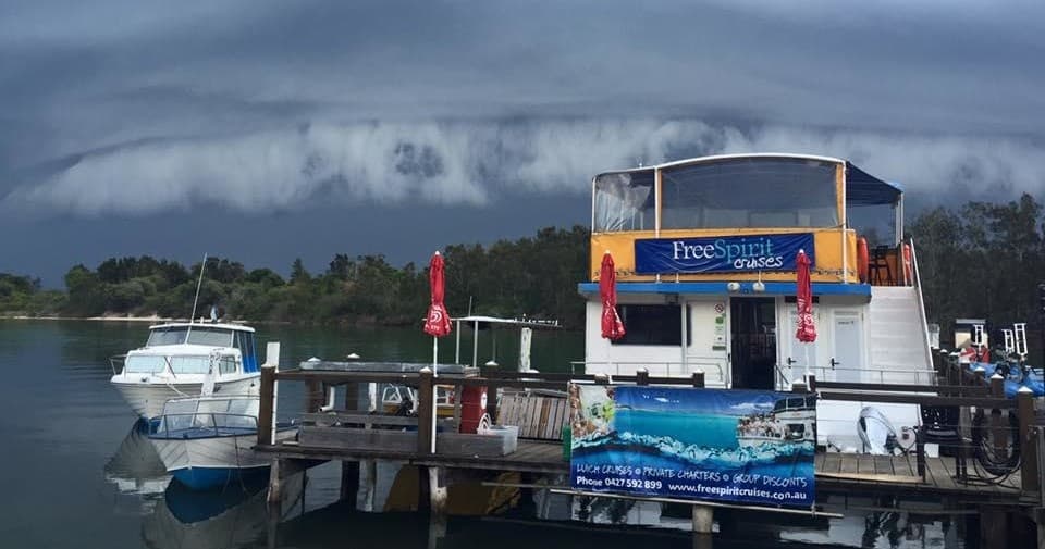 Sightseeing vessel moored at marina under dramatic storm clouds