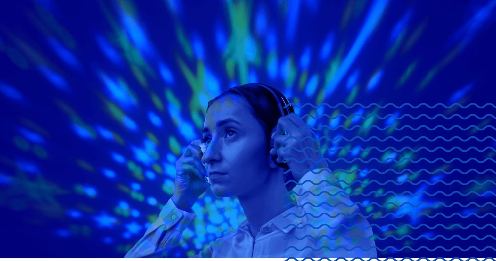 Woman wearing headphones listening to immersive audio in blue-lit studio