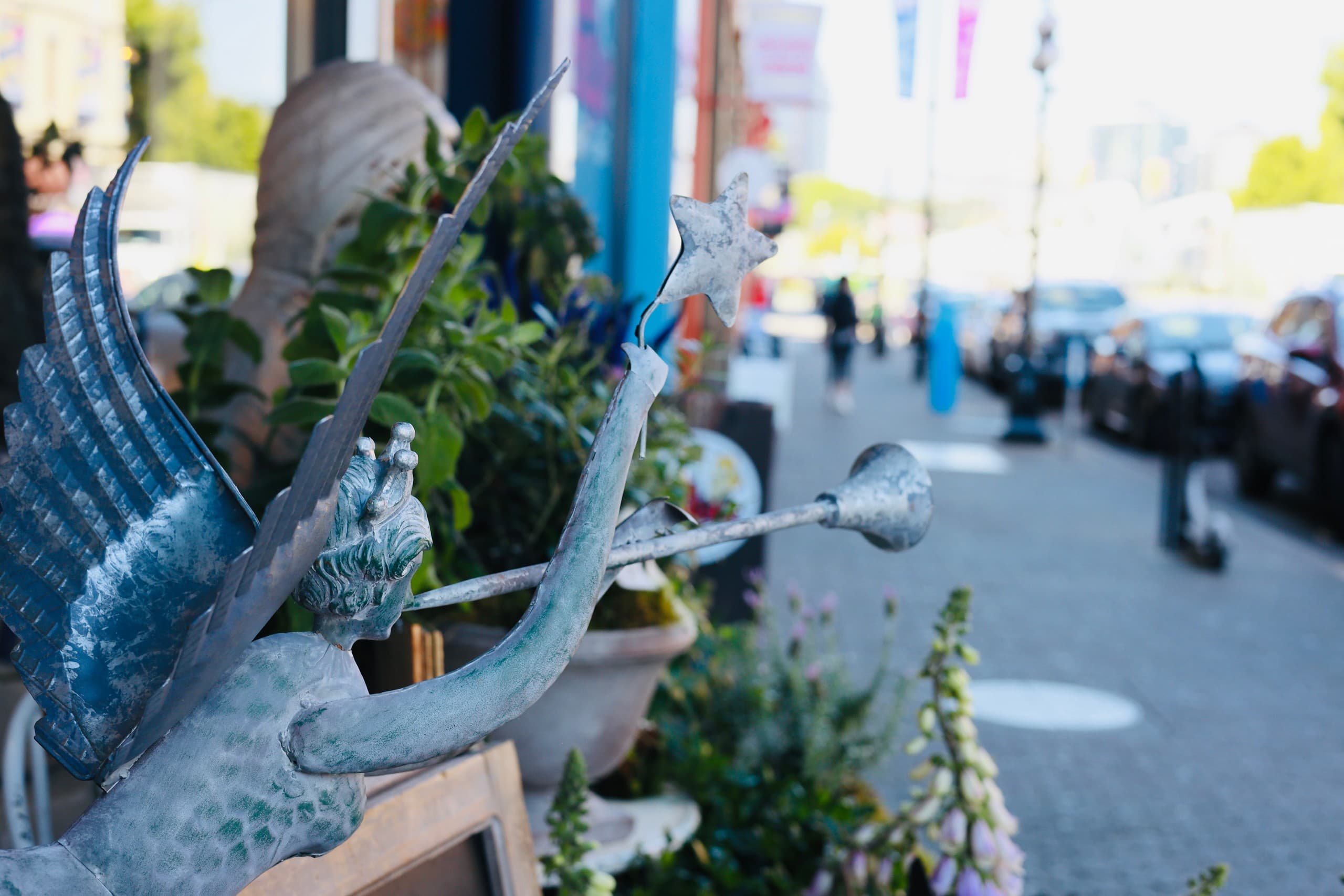 Outdoor shop display and decorative statue on busy sidewalk