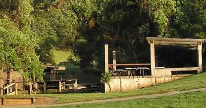 Wooden shooting pavilion and scenic grassy grounds at range