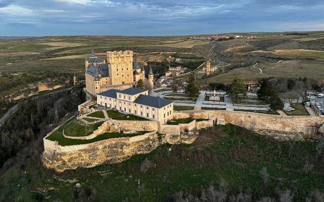 Aerial view of historic hilltop castle and grounds in countryside