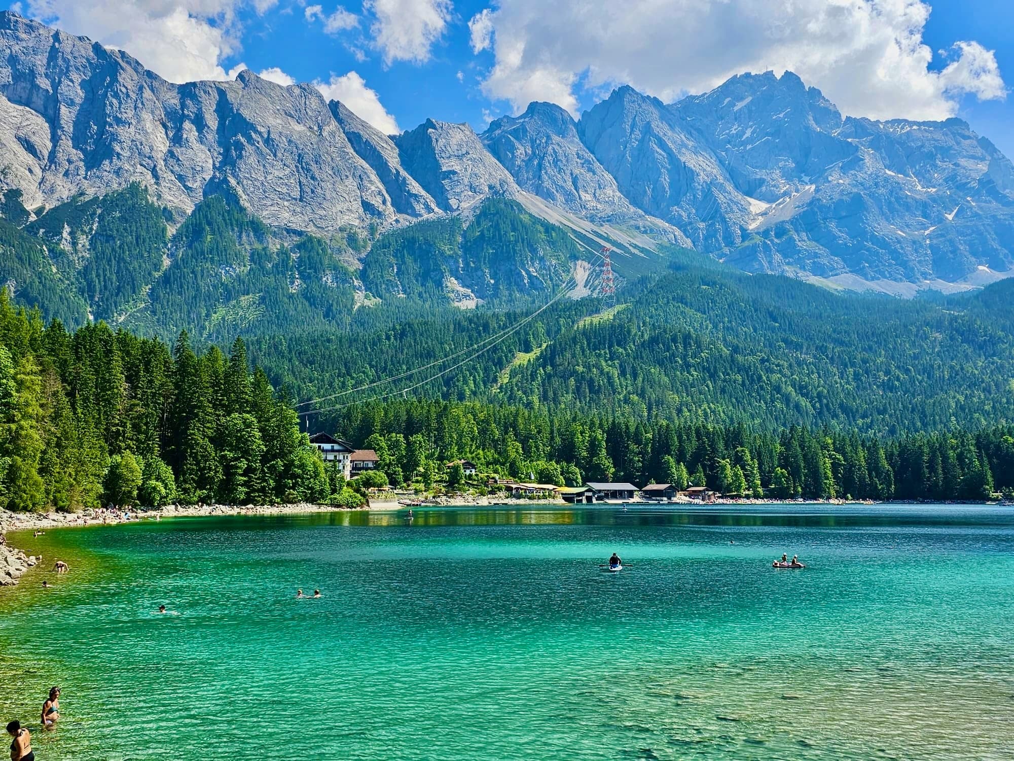 Emerald alpine lake with paddlers and mountain backdrop in Bavarian Alps