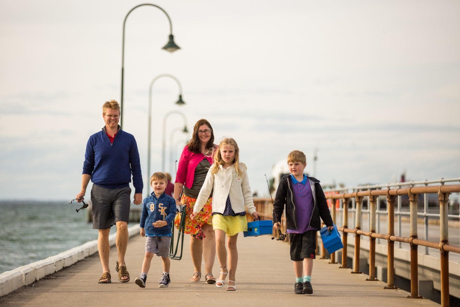 Family walking along seaside pier at Port Phillip coastal stroll