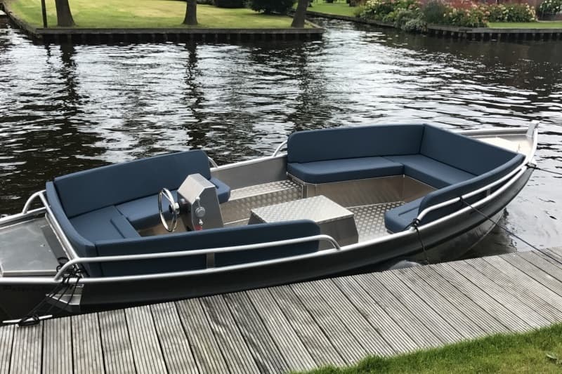 Empty rental boat moored at wooden dock on calm canal