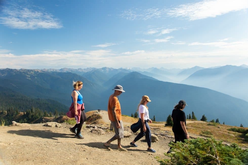 Group hiking along mountain ridge with panoramic alpine views