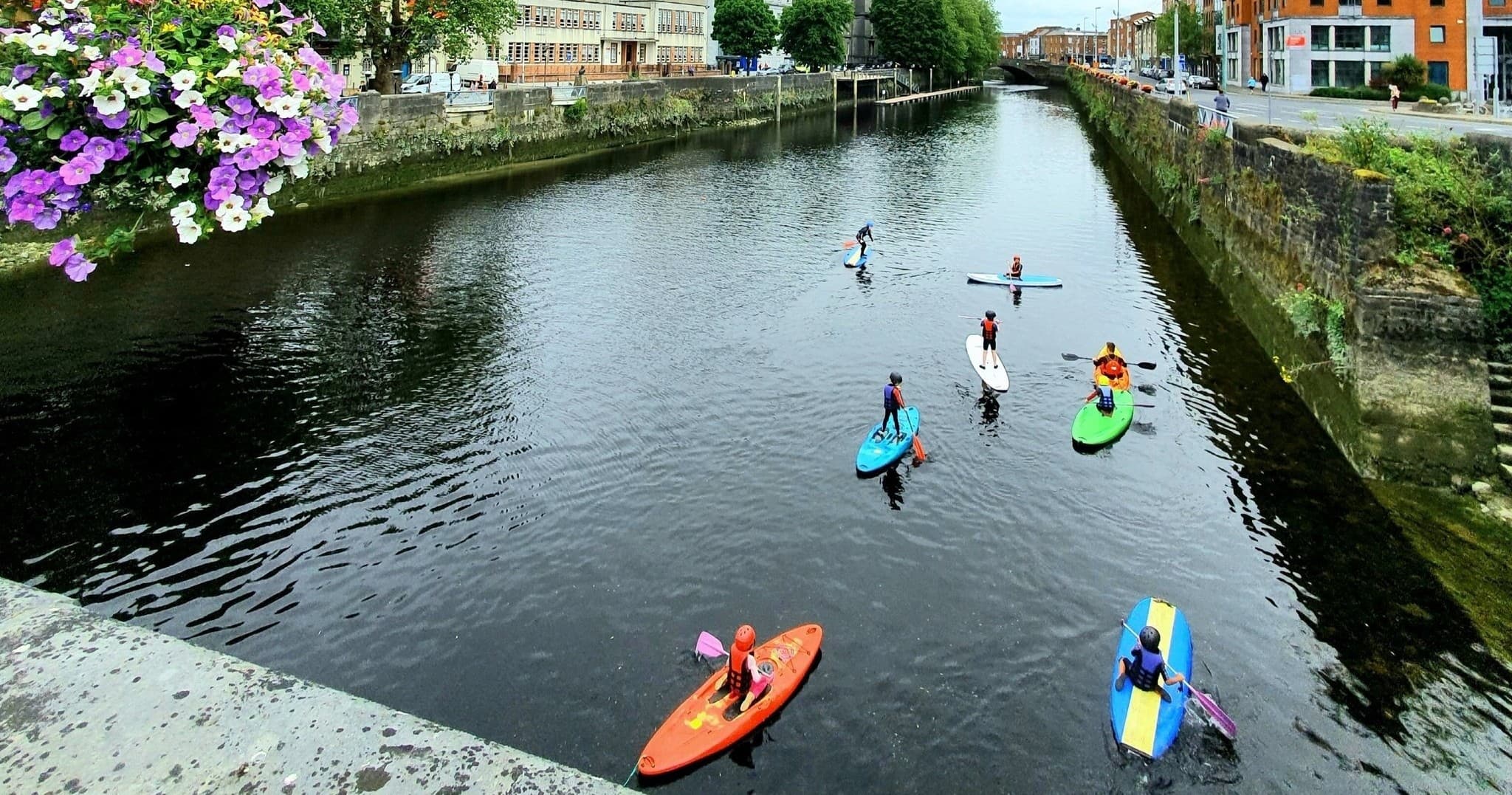 Group paddlers kayaking down scenic town canal on calm water