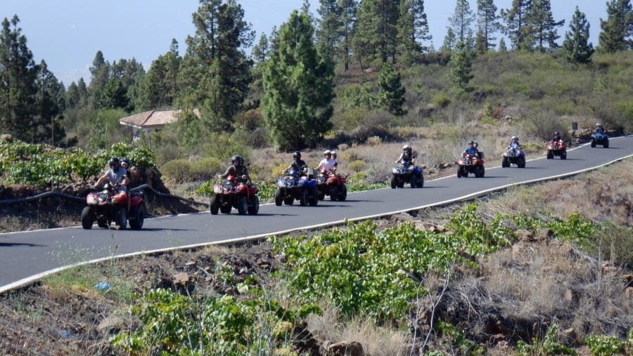 Quad bikes riding along scenic volcanic road in Tenerife