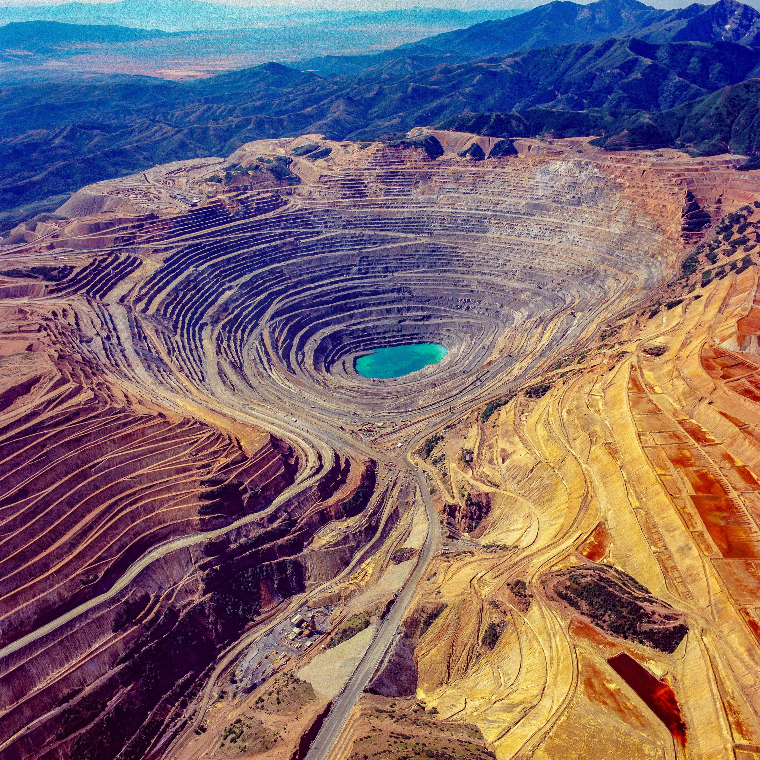 Aerial view of massive open pit mine with vivid terraced layers