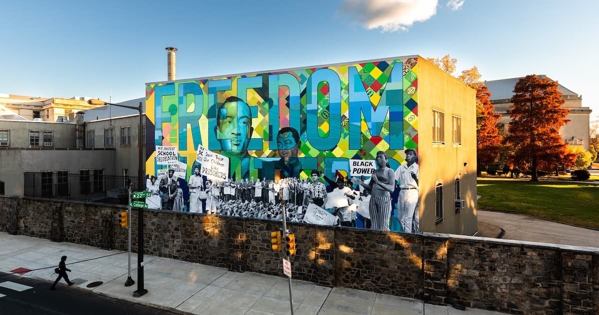 Large Freedom rooftop mural on city wall with open plaza view