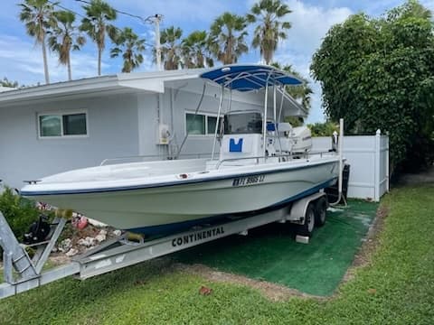 Trailered center console boat parked in yard, ready for transport