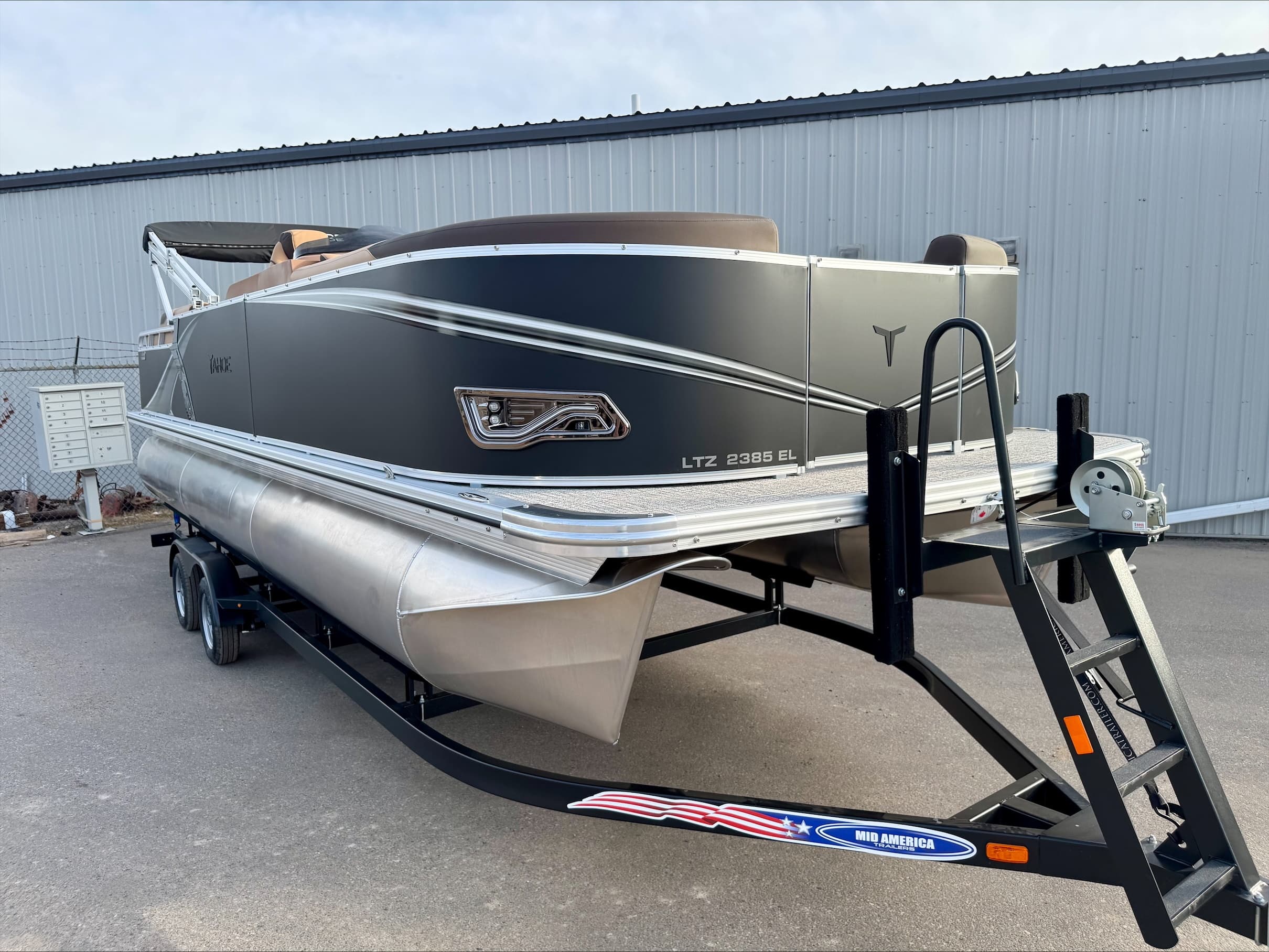 Pontoon boat on trailer parked at marina lot ready for water