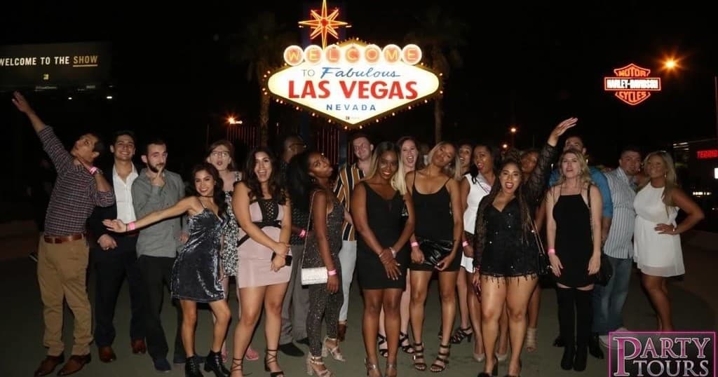 Bachelorette group posing under Welcome to Las Vegas sign on Strip