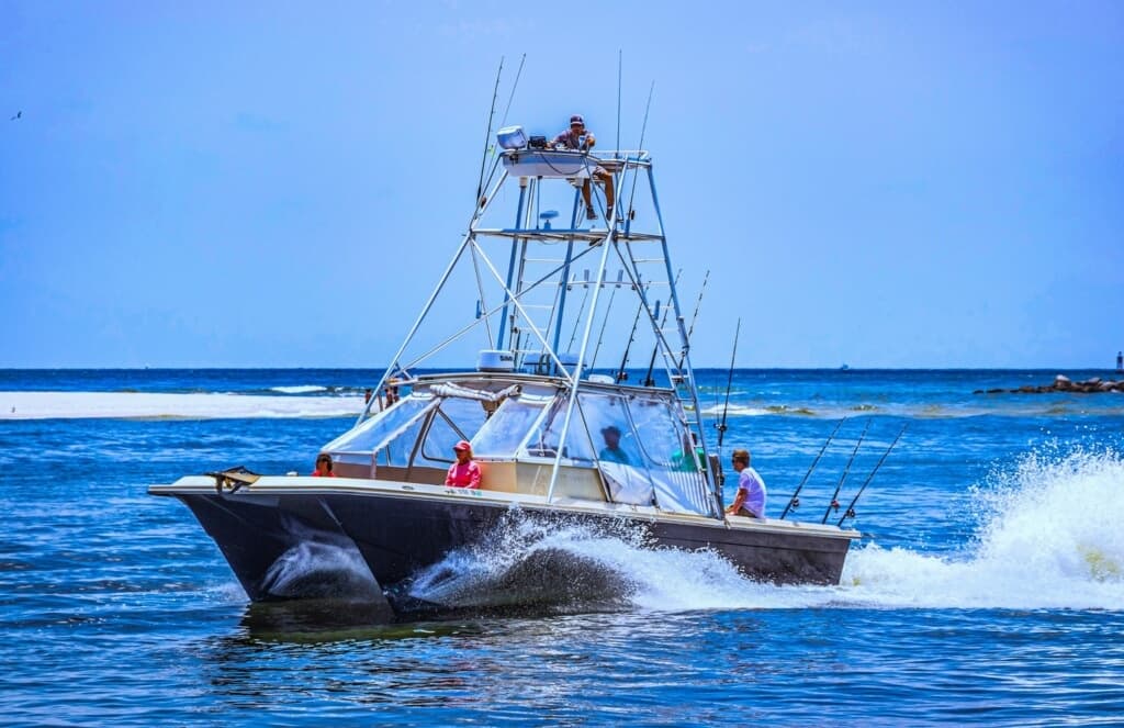 Sportfishing boat speeding across blue Gulf waters near shore