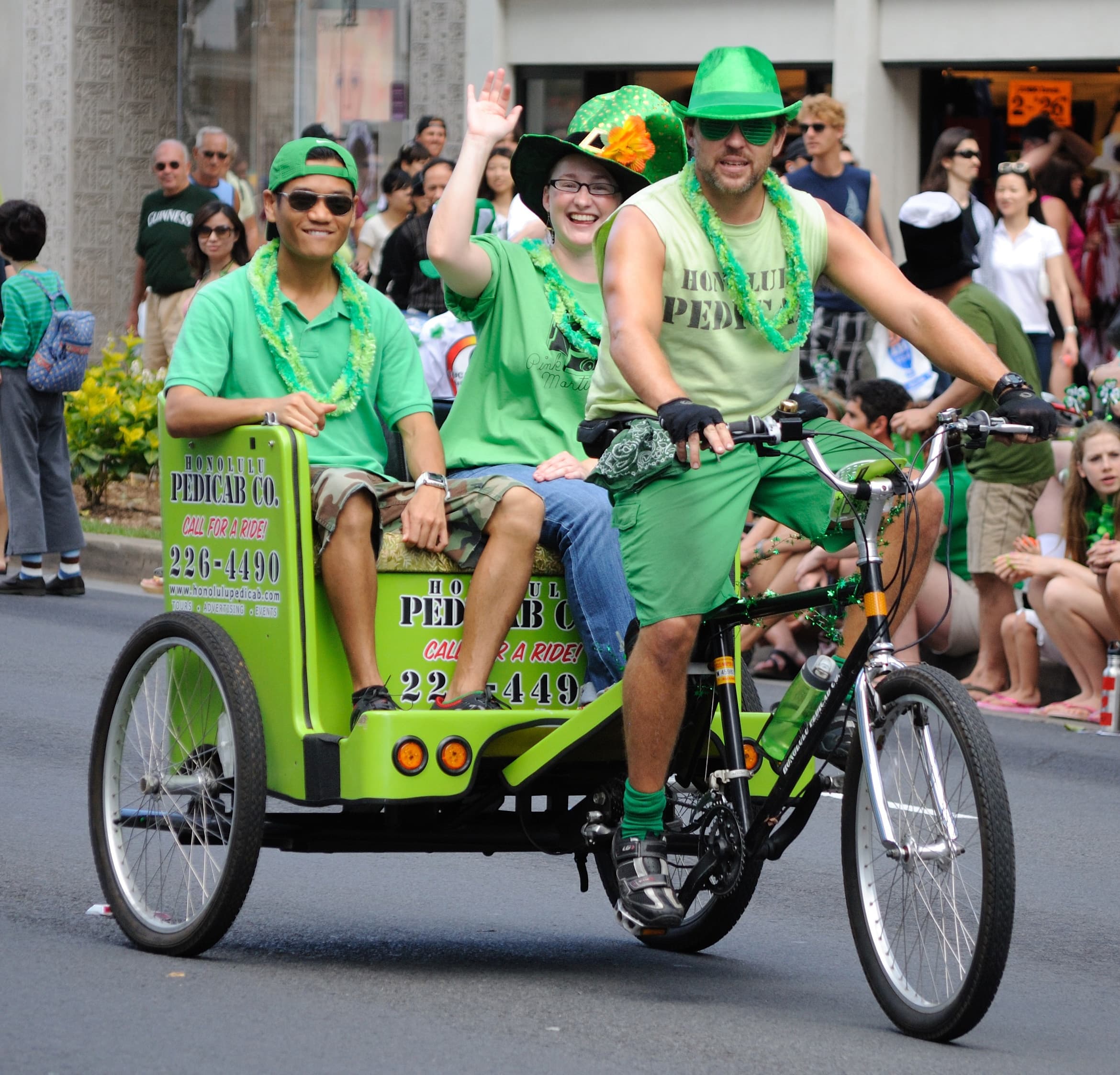 Colorful pedicab parade on city street with smiling riders