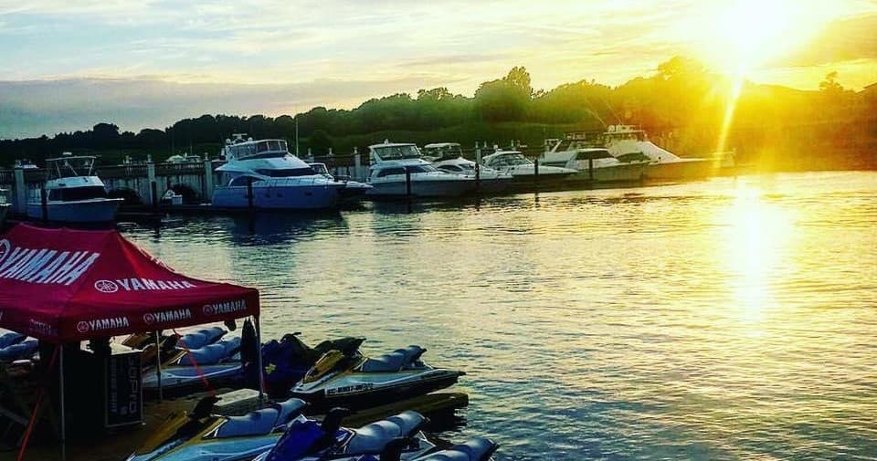 Marina at sunset with moored boats and golden water reflections