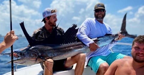 Group anglers displaying freshly caught billfish during charter trip