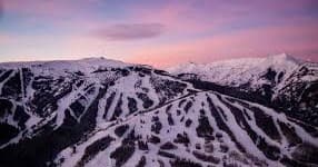 Sunset aerial of ski resort trails with dramatic purple twilight