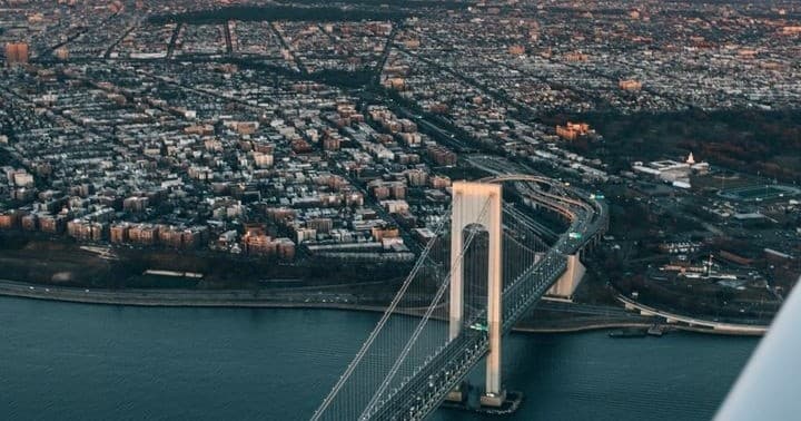 Aerial view of suspension bridge and waterfront cityscape, scenic