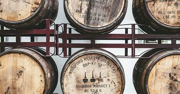 Aging beer oak barrels stacked in brewery cellar racks