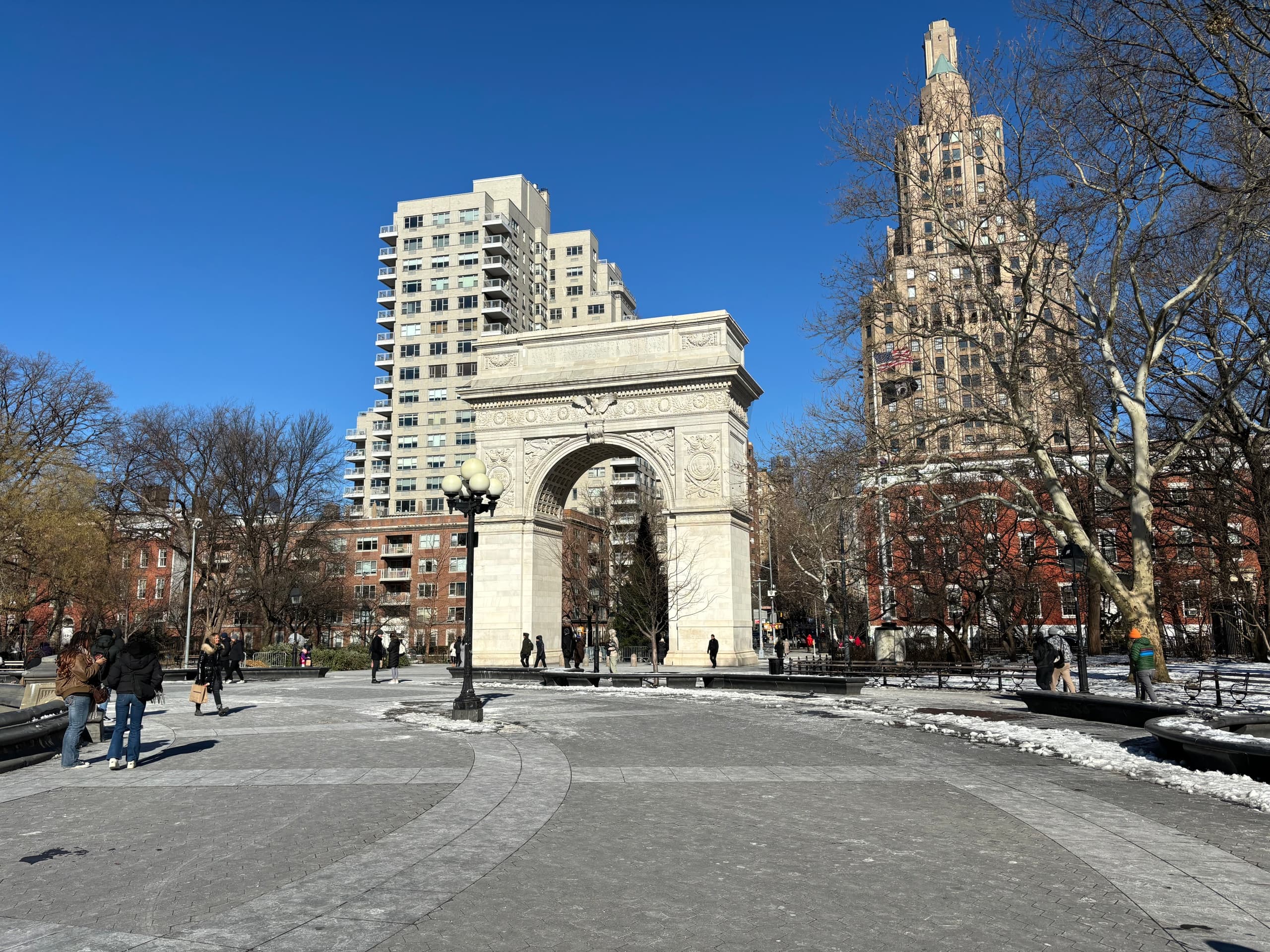 Washington Square Arch in park with visitors, urban stroll