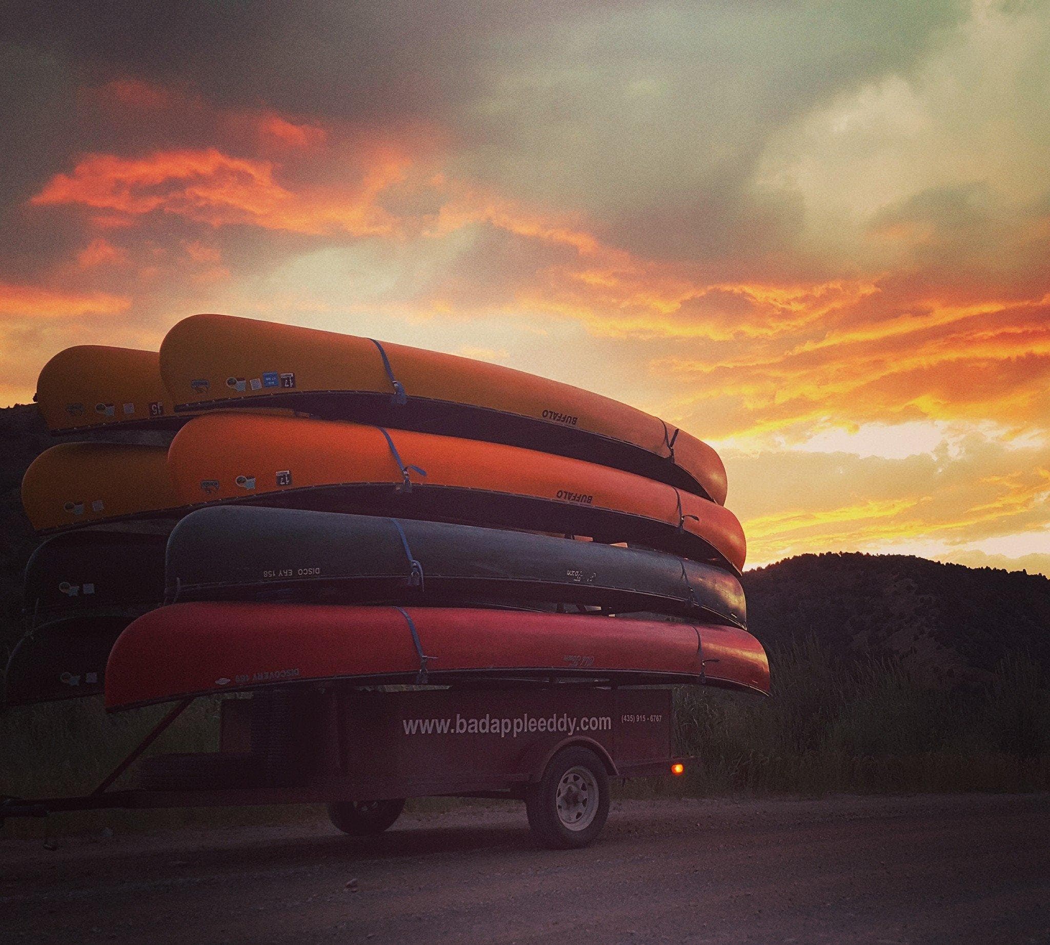 Stacked rafts on trailer at sunset at river outfitter lot