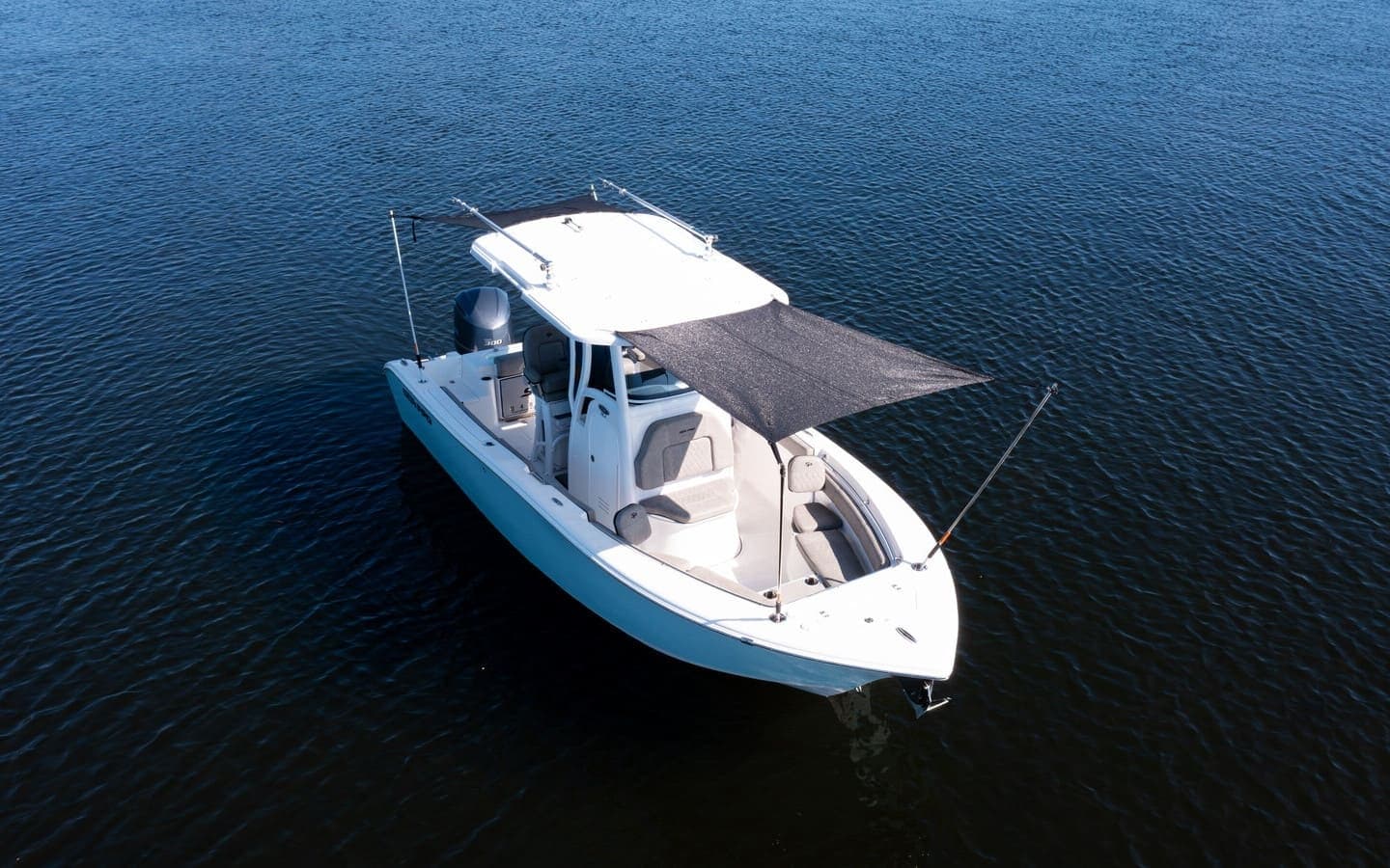 White motorboat anchored in open coastal Florida waters, aerial view