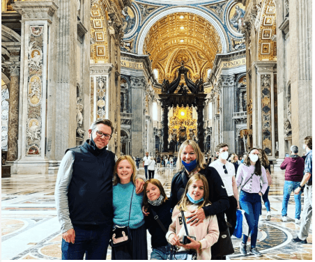 Family visiting ornate interior of St. Peter's Basilica in Vatican